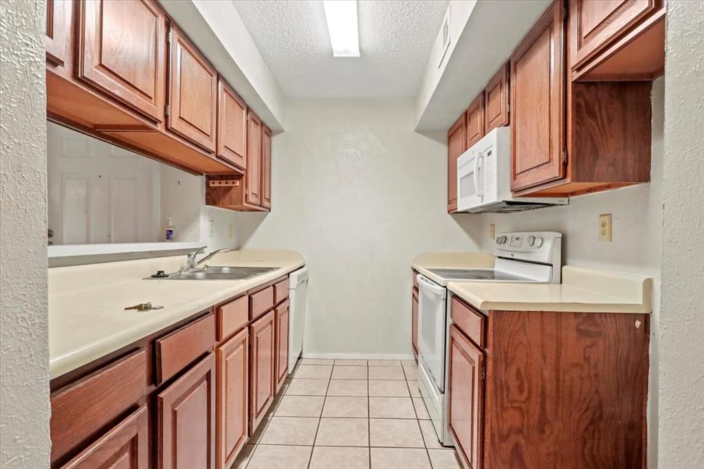 11460 Audelia Road, Unit 172 Dallas, TX 75243 - Photo 20 of 38 a kitchen with stainless steel appliances granite countertop a sink and dishwasher a stove top oven with wooden floor