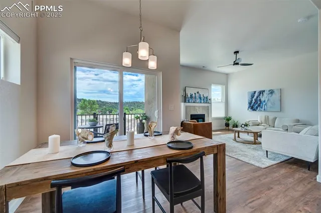 a dining room with wooden floor a chandelier a wooden table and chairs