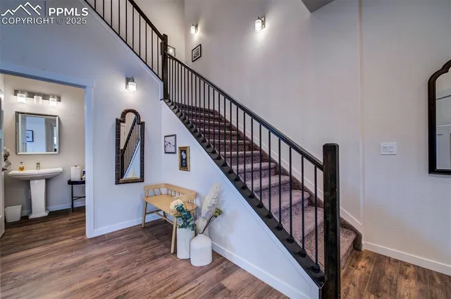 a hallway with wooden floor stairs and a dining table