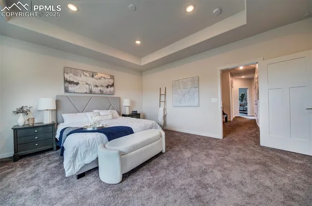 a spacious bedroom with a bed and a painting on the wall