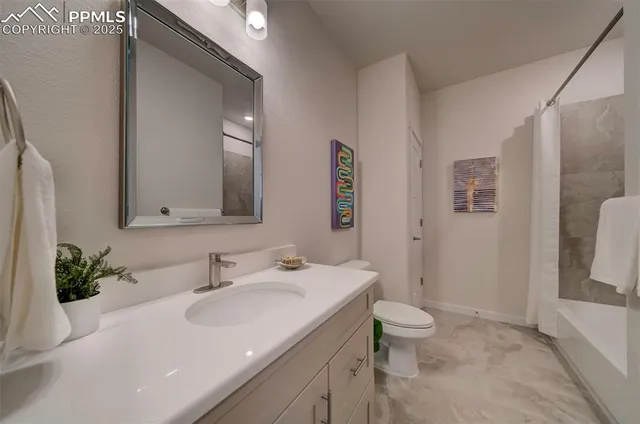 a bathroom with a sink a toilet and a large mirror