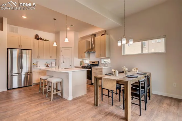 a kitchen with a table chairs refrigerator and microwave