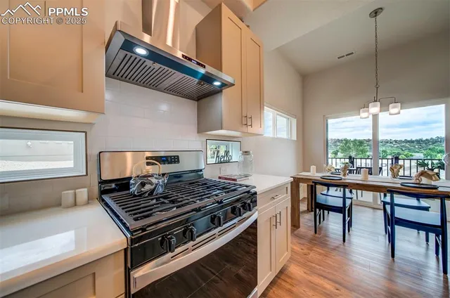 a kitchen with a stove a window and chairs