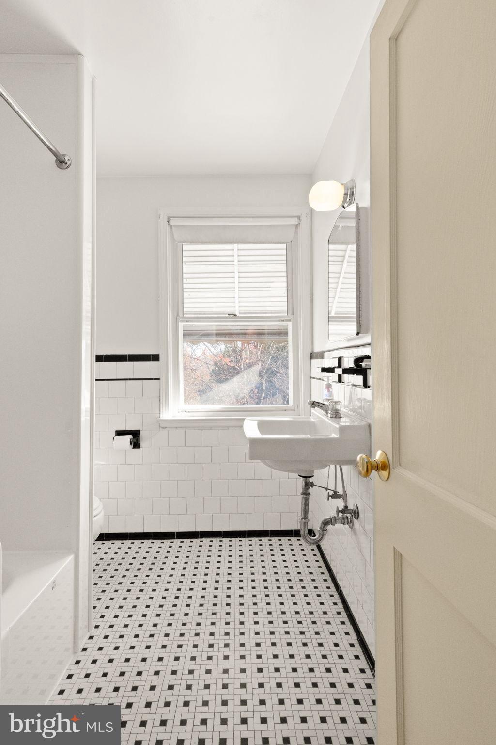 6822 Everall Avenue Baltimore, MD 21206 - Photo 13 of 21 a bathroom with a sink a mirror and a shower