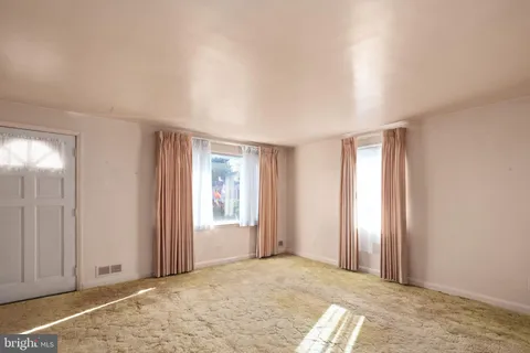 a view of a livingroom with an empty space and a window