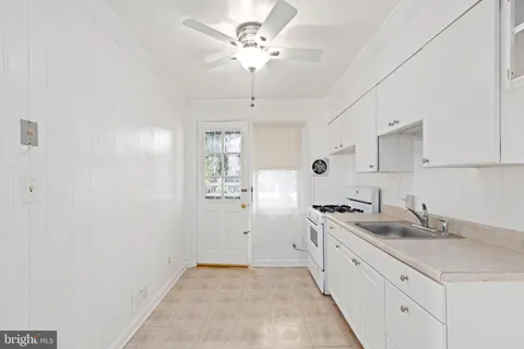 a kitchen with white cabinets and white appliances
