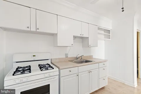a kitchen with white cabinets and white appliances