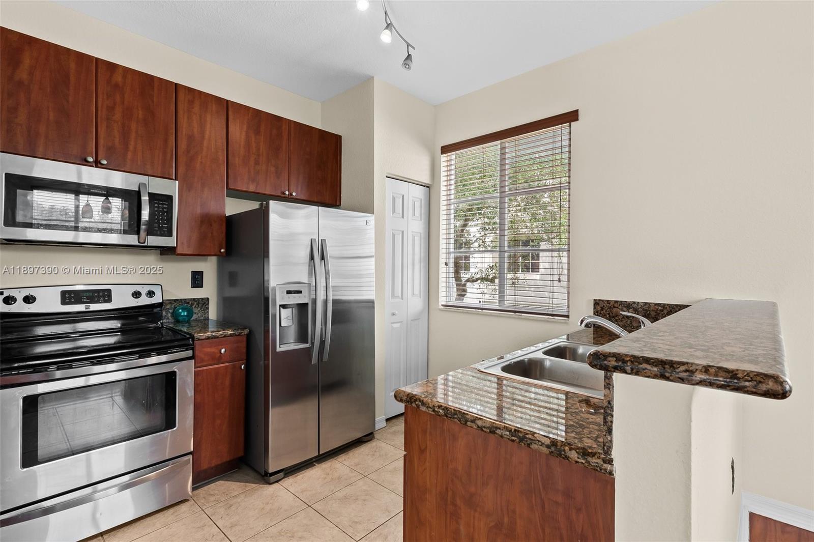 12421 Southwest 50th Court, Unit 347 Miramar, FL 33027 - Photo 19 of 25 a kitchen with granite countertop a refrigerator stove and microwave