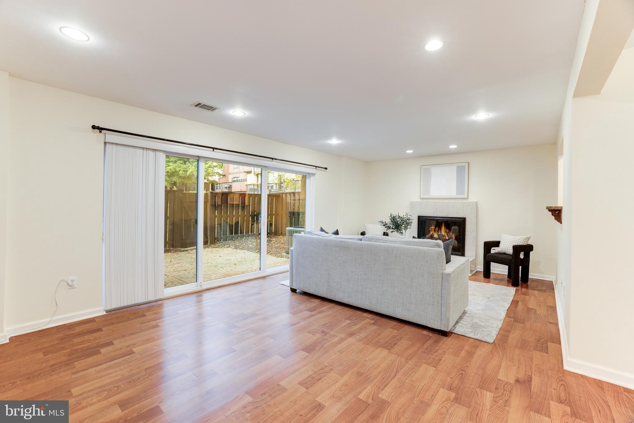 11102 Saffold Way Reston, VA 20190 - Photo 12 of 27 a living room with furniture floor to ceiling window and wooden floor