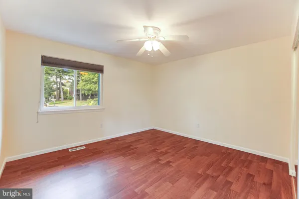 a view of empty room with wooden floor