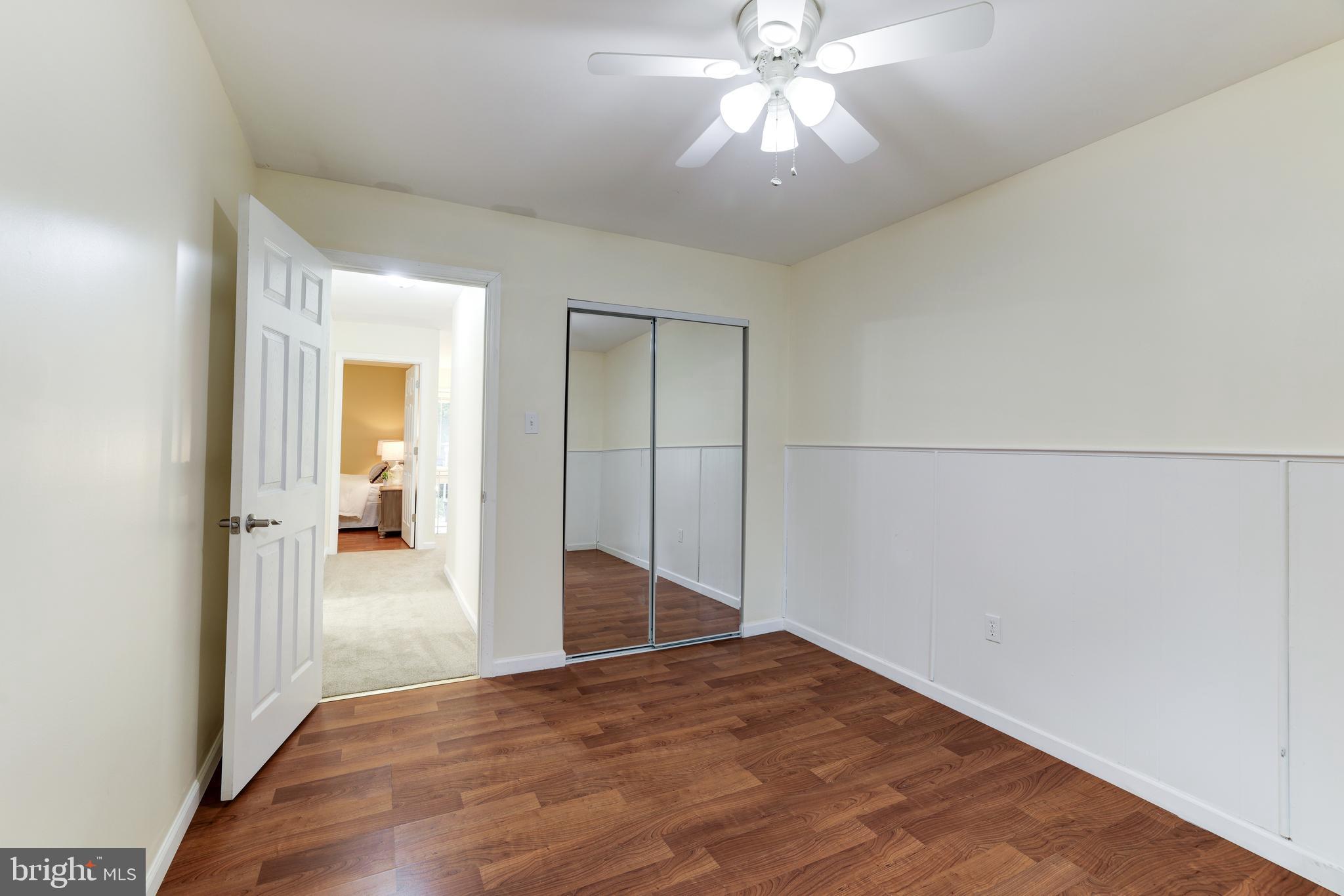 11102 Saffold Way Reston, VA 20190 - Photo 20 of 27 an empty room with wooden floor fan and windows