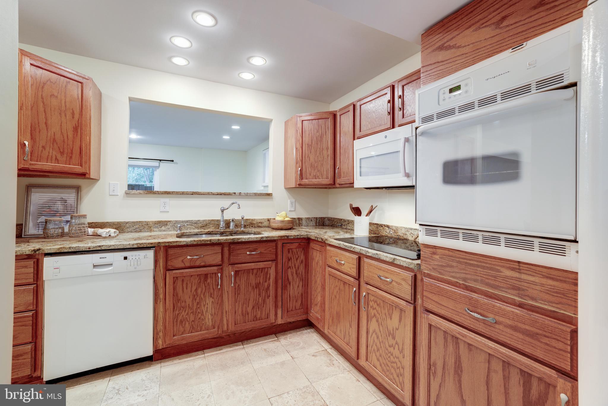 11102 Saffold Way Reston, VA 20190 - Photo 7 of 27 a kitchen with stainless steel appliances granite countertop wooden cabinets a sink and dishwasher