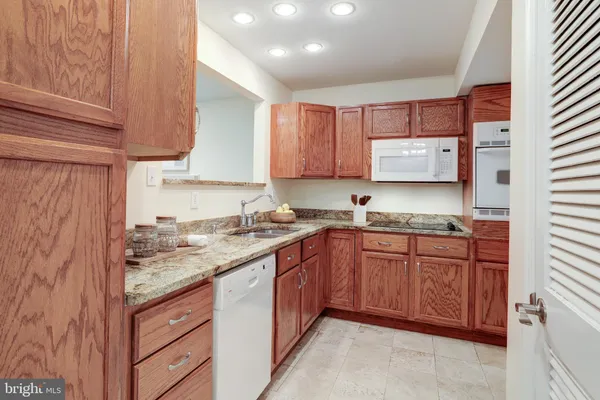 a kitchen with stainless steel appliances granite countertop a sink stove and cabinets