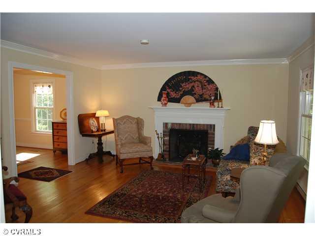 3919 Cresthill Road Chester, VA 23831 - Photo 3 of 7 Exterior Front - Large living room with hardwood floors, crown molding and wood burning fireplace. Room has large opening to dining room and kitchen area.