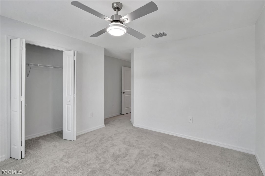 19931 Green Pasture Road Lehigh Acres, FL 33974 - Photo 8 of 19 an empty room with a fan and a ceiling fan