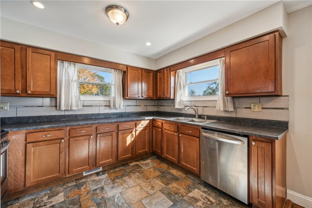 306 Highland Ridge Road Claysville, PA 15323 - Photo 12 of 37 a kitchen with stainless steel appliances granite countertop wooden cabinets a sink and dishwasher with a large window