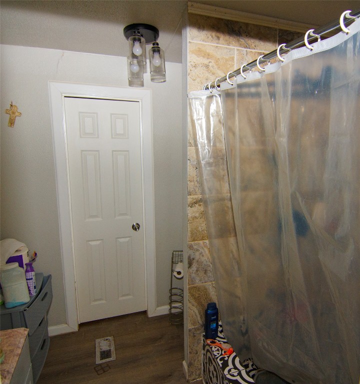 155 Arbuckle Road Elgin, TX 78621 - Photo 12 of 16 Bathroom featuring a shower with shower curtain, dark wood finished floors, and vanity