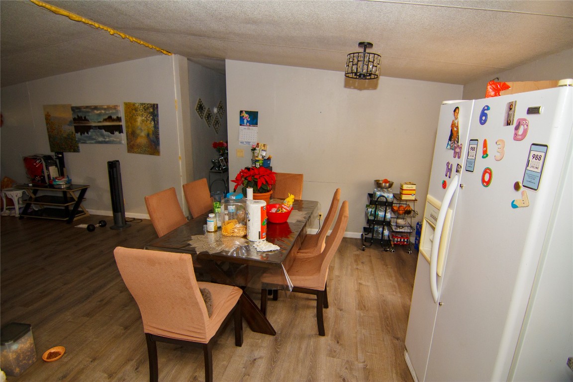 155 Arbuckle Road Elgin, TX 78621 - Photo 14 of 16 Dining area with wood finished floors and a textured ceiling