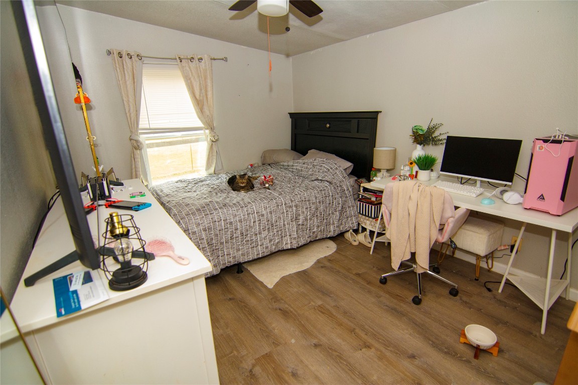 155 Arbuckle Road Elgin, TX 78621 - Photo 15 of 16 Bedroom with light wood finished floors, an office area, and a ceiling fan