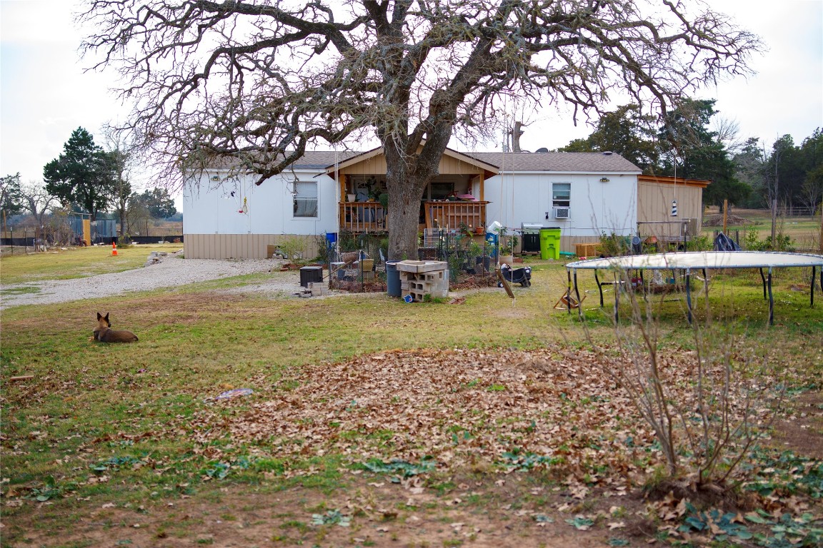 155 Arbuckle Road Elgin, TX 78621 - Photo 2 of 16 Back of house featuring a trampoline