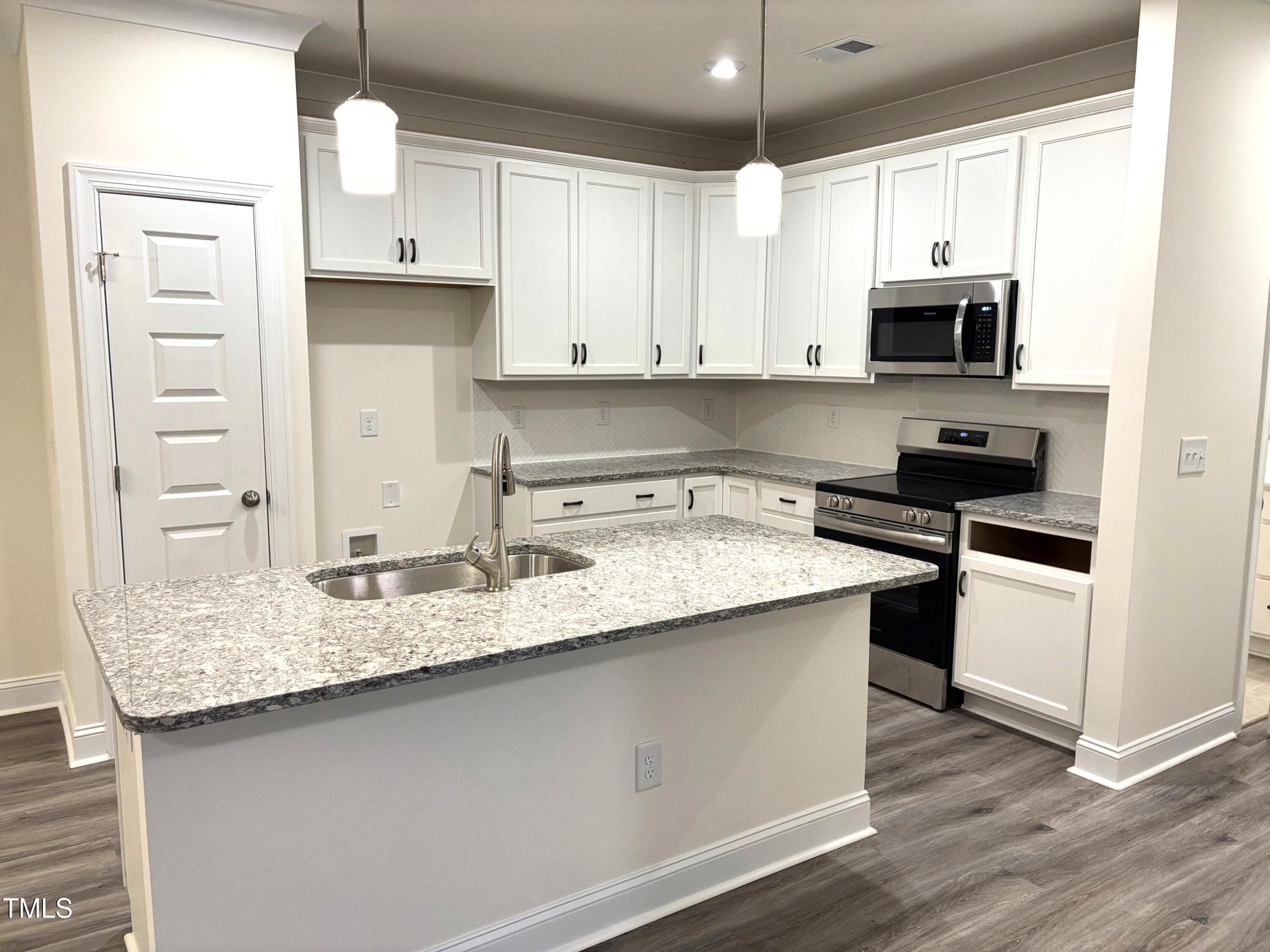 602 Weather Ridge Lane, Unit 21 Cary, NC 27513 - Photo 3 of 19 a kitchen with stainless steel appliances granite countertop a sink stove and microwave