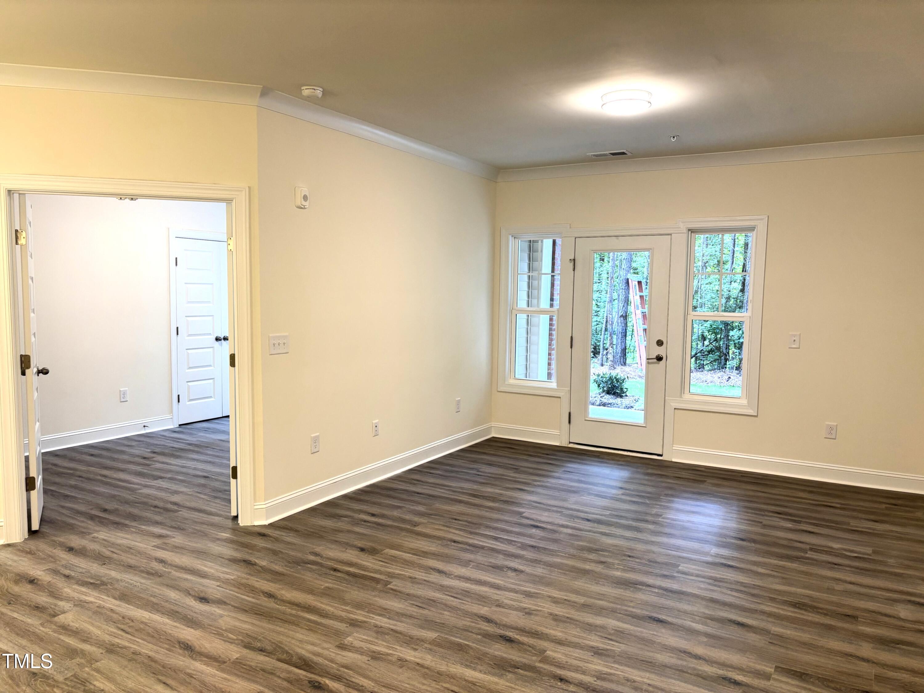 602 Weather Ridge Lane, Unit 21 Cary, NC 27513 - Photo 5 of 19 an empty room with wooden floor and windows
