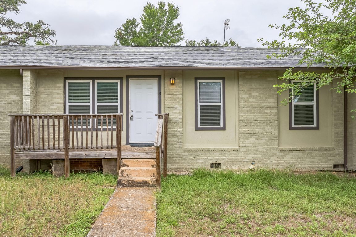 a view of a house with a small deck and wooden floor