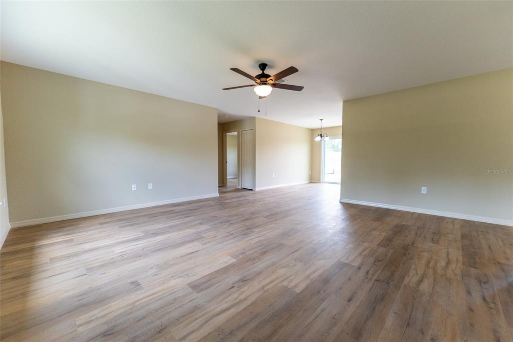 23855 Southwest White Sands Road Dunnellon, FL 34431 - Photo 2 of 42 an empty room with wooden floor and windows