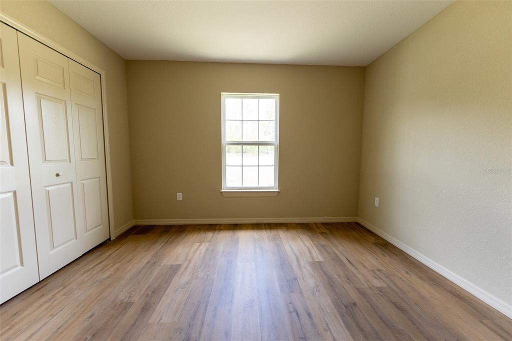 23855 Southwest White Sands Road Dunnellon, FL 34431 - Photo 26 of 42 a view of an empty room with wooden floor and a window