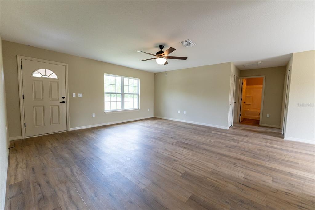 23855 Southwest White Sands Road Dunnellon, FL 34431 - Photo 4 of 42 an empty room with wooden floor and windows