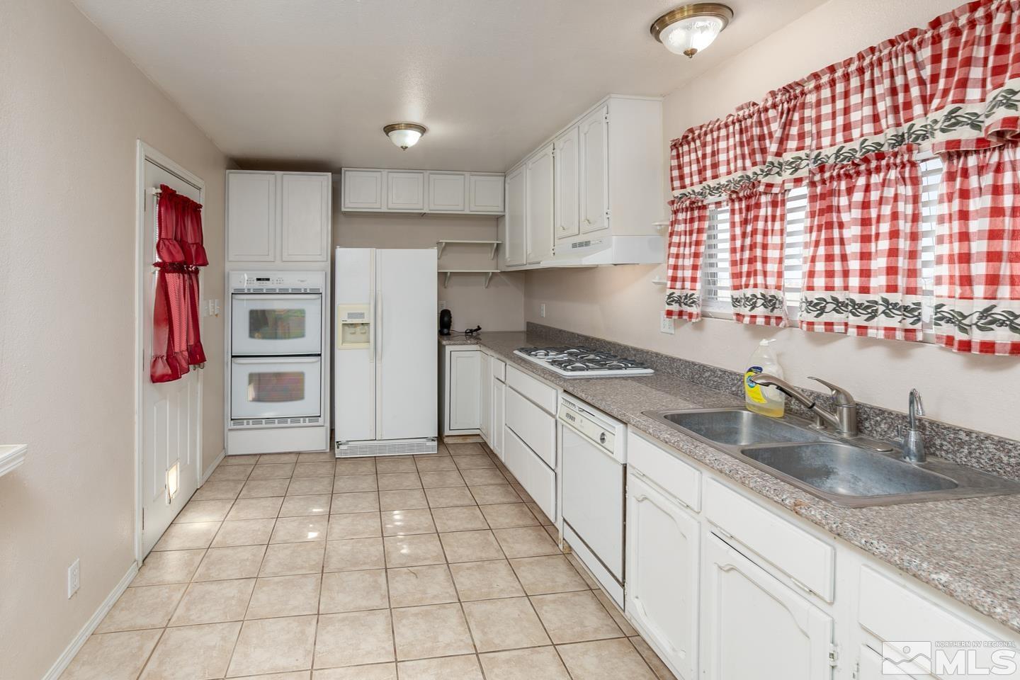 4100 Edwards Lane Fallon, NV 89406 - Photo 14 of 23 a kitchen with granite countertop a refrigerator and a sink