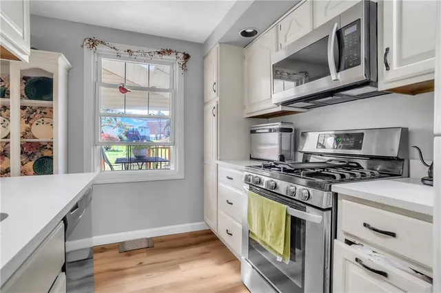 a kitchen with stainless steel appliances granite countertop a stove and a microwave