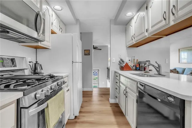 a kitchen with stainless steel appliances a sink dishwasher stove and refrigerator