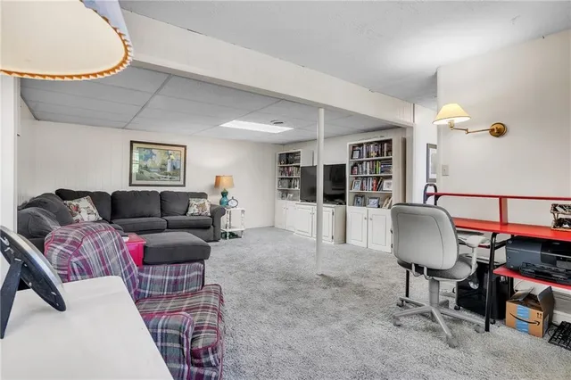 a living room with furniture a glass top table and a flat screen tv