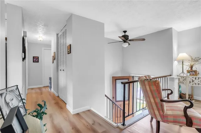 a view of a hallway with workspace and wooden floor