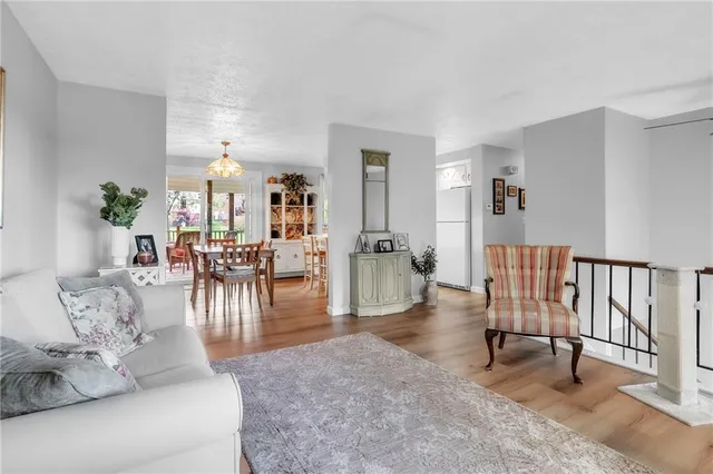 a living room with furniture and a dining table with wooden floor