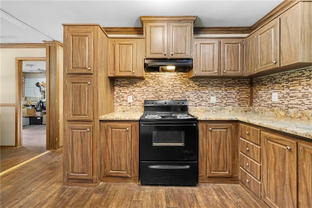 a kitchen with granite countertop wooden cabinets and stainless steel appliances