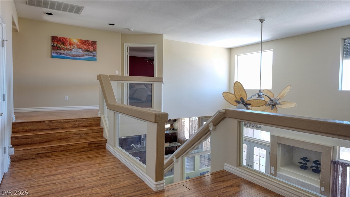 3704 North Campbell Road Las Vegas, NV 89129 - Photo 32 of 46 Natural light floods this inviting entryway, boasting warm hardwood flooring and modern glass railings.