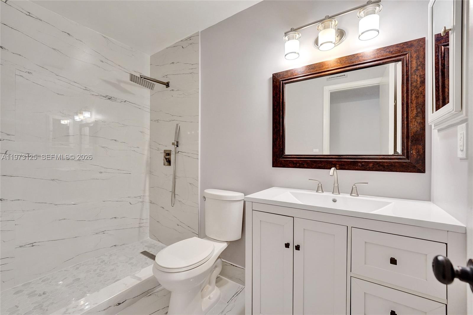 9340 Southwest 61st Way, Unit B Boca Raton, FL 33428 - Photo 15 of 25 a bathroom with a toilet sink and shower