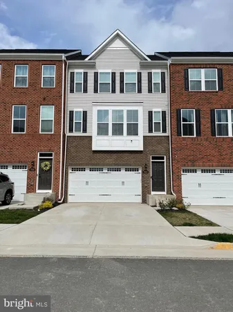 a front view of a house with yard and parking