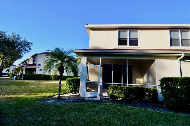 a front view of a house with a yard and potted plants