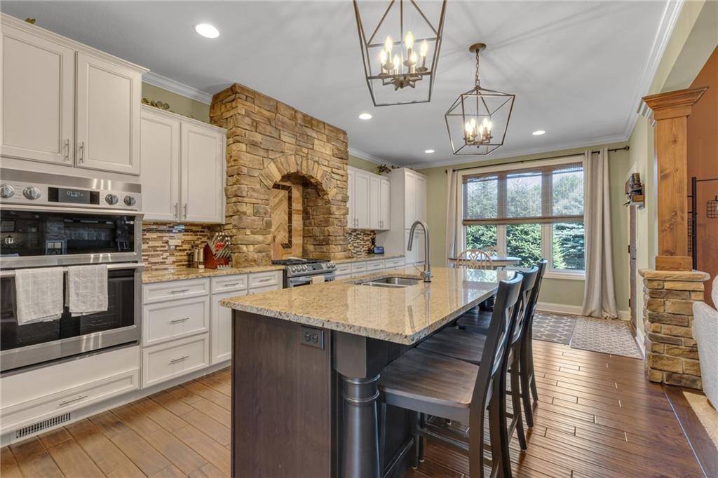125 James Drive Beaver, PA 15009 - Photo 3 of 40 a kitchen with stainless steel appliances granite countertop a stove a refrigerator a sink a dining table and chairs with wooden floor
