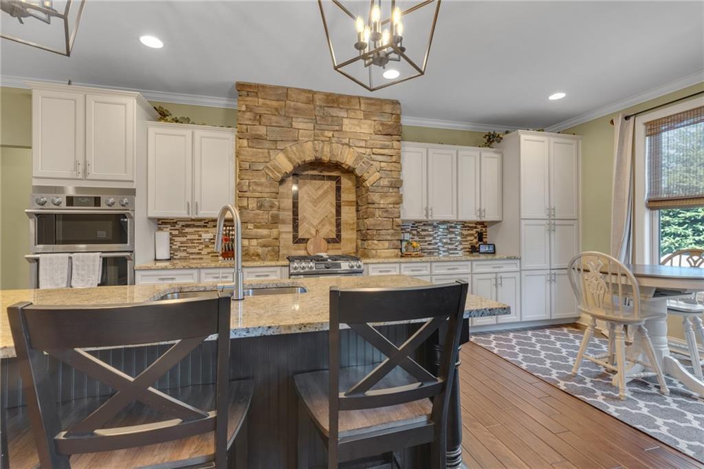 125 James Drive Beaver, PA 15009 - Photo 10 of 40 a kitchen with stainless steel appliances granite countertop a stove top oven a sink dishwasher a dining table and chairs with wooden floor