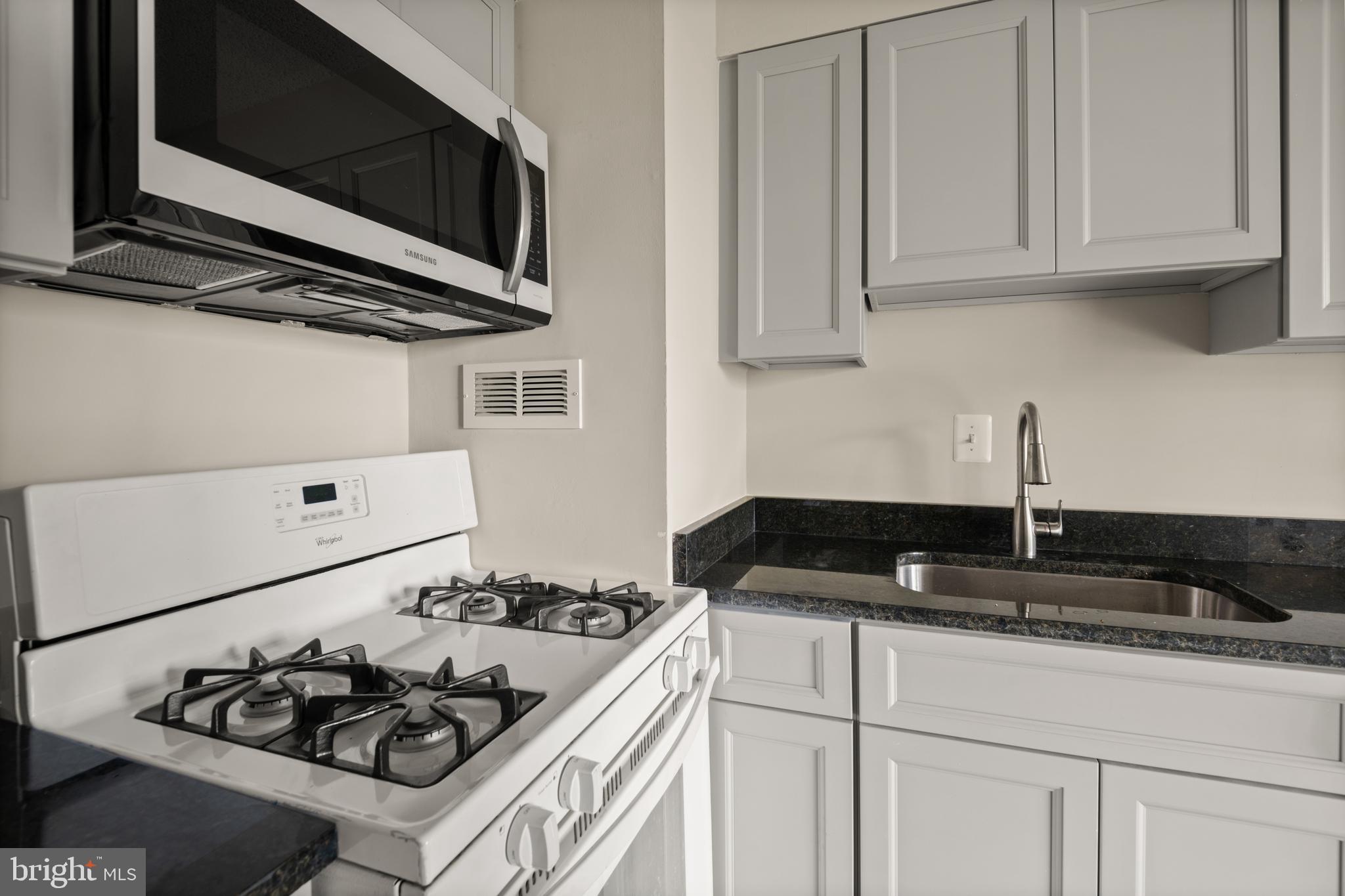 1824 Metzerott Road, Unit 303 Adelphi, MD 20783 - Photo 18 of 28 a kitchen with stainless steel appliances granite countertop white cabinets and stove