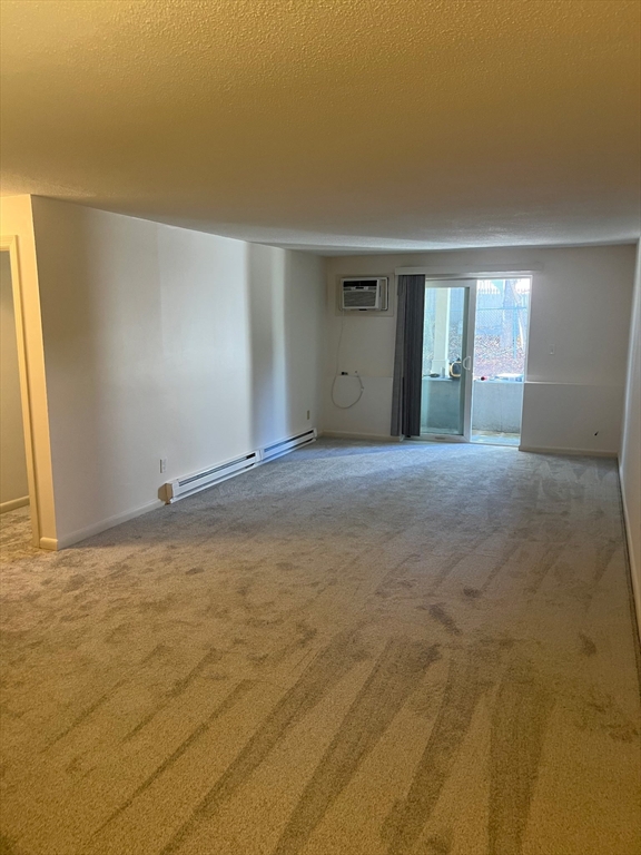 200 Manning Street, Unit 6C Hudson, MA 01749 - Photo 3 of 6 a view of an empty room with window and a kitchen