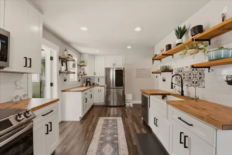 a large kitchen with stainless steel appliances kitchen island granite countertop a lot of counter space and wooden floor