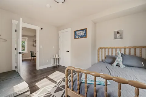 a bedroom with a bed and wooden floor