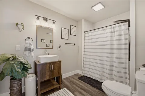 a bathroom with a sink a toilet and shower
