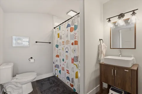 a bathroom with a sink a toilet and shower
