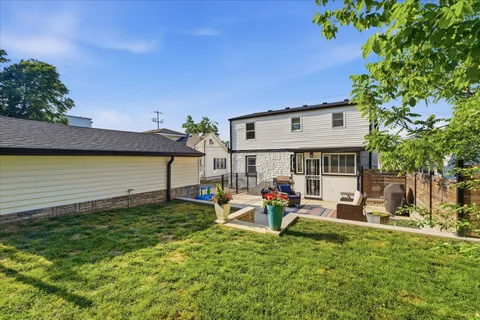 a view of a house with backyard and sitting area